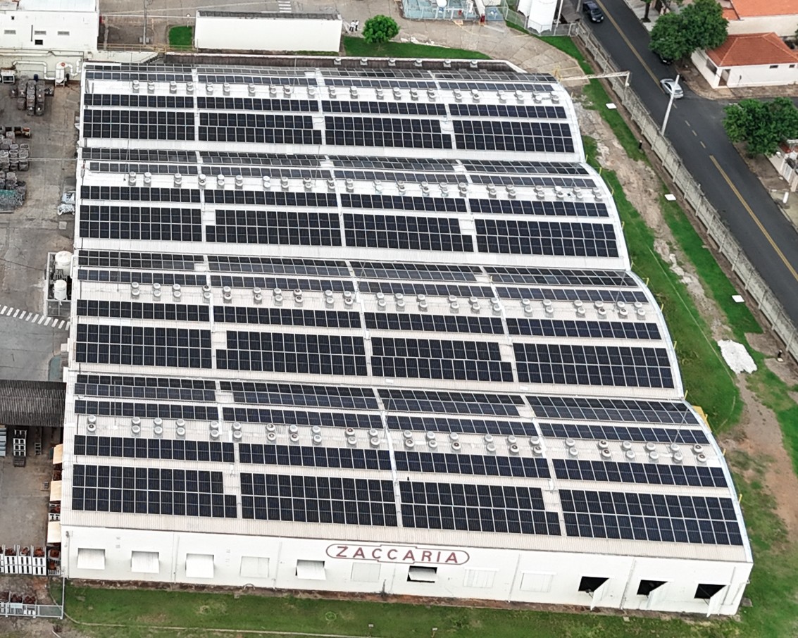 Usina solar sobre telhado industrial da fábrica Zaccaria, vista aérea de painéis fotovoltaicos em galpão